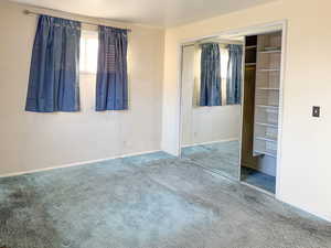 Unfurnished bedroom featuring carpet flooring and a closet