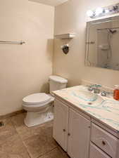 Bathroom featuring tile patterned flooring, vanity, and toilet