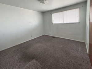 Unfurnished room featuring dark colored carpet