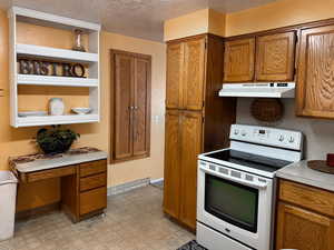 Kitchen featuring a textured ceiling and white electric stove