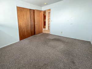 Unfurnished bedroom with a closet and carpet floors