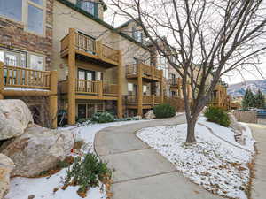 Snow covered rear of property with a mountain view