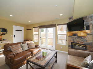 Living room with carpet and a stone fireplace