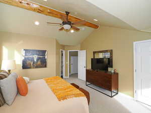 Carpeted bedroom featuring vaulted ceiling with beams and ceiling fan