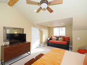 Carpeted bedroom with vaulted ceiling with beams and ceiling fan