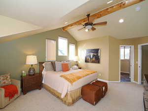 Bedroom with multiple windows, ceiling fan, light carpet, and lofted ceiling with beams