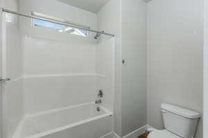 Bathroom featuring toilet and bathtub / shower combination