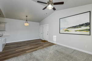 Interior space featuring dark wood-type flooring, lofted ceiling, and ceiling fan