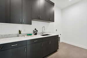 Kitchen with light stone countertops and sink