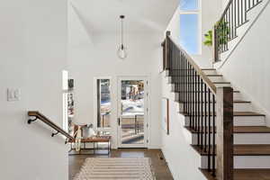 Stairway with wood-type flooring and a high ceiling