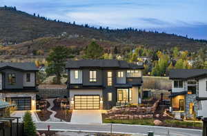 View of front of property with central AC, a mountain view, and a garage