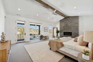 Bedroom featuring access to exterior, ceiling fan, vaulted ceiling with beams, light carpet, and a fireplace