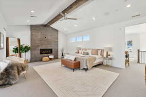 Bedroom featuring vaulted ceiling with beams, ceiling fan, light colored carpet, and a tile fireplace