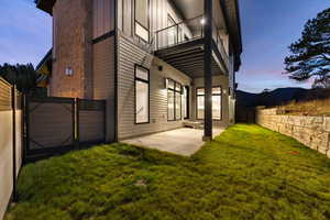 Exterior space featuring a mountain view, a yard, a balcony, and a patio area