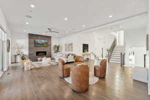 Living room with hardwood / wood-style flooring, ceiling fan, and a fireplace