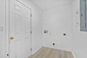 Washroom with hookup for an electric dryer, washer hookup, and light hardwood / wood-style floors