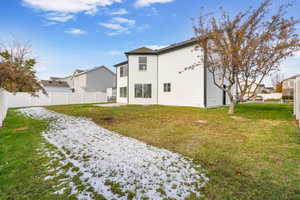 Rear view of property with a yard