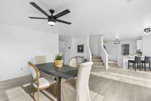 Dining space with ceiling fan and light wood-type flooring