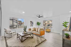 Living room with ceiling fan and light hardwood / wood-style floors