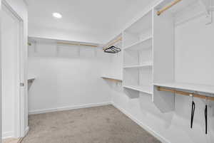 Spacious closet with light colored carpet