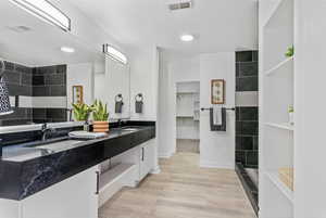 Bathroom with a shower, vanity, and wood-type flooring