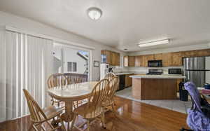 Dining space with a textured ceiling and light wood-type flooring