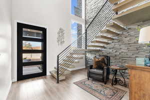 Foyer featuring a towering ceiling and light hardwood / wood-style floors