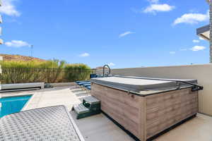 View of pool with a patio and a hot tub