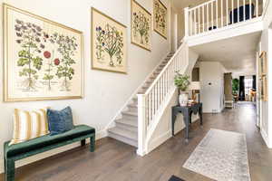 Stairway with a towering ceiling and hardwood / wood-style flooring