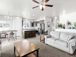 Living room featuring sink, light hardwood / wood-style floors, and ceiling fan with notable chandelier