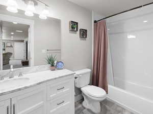 Full bathroom with wood-type flooring, vanity, toilet, and shower / bath combo