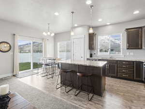 Kitchen featuring a kitchen breakfast bar, a center island, light hardwood / wood-style flooring, and plenty of natural light