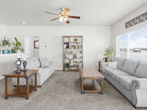 Carpeted living room with ceiling fan