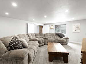 Living room with light colored carpet and a textured ceiling