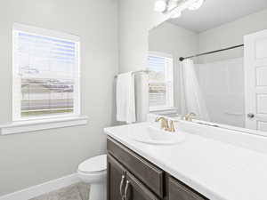 Bathroom with tile patterned flooring, vanity, and toilet