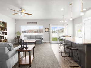 Carpeted living room featuring ceiling fan with notable chandelier