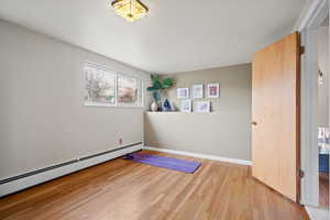 Empty room featuring light hardwood / wood-style floors and a baseboard radiator