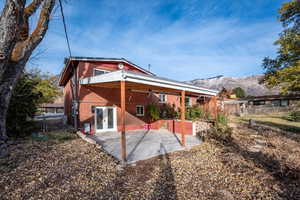 Rear view of house featuring a mountain view, french doors, and a patio