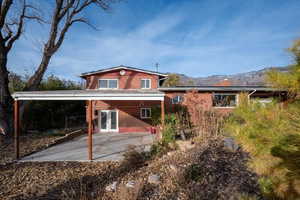 Back of house featuring a mountain view, a patio, and french doors