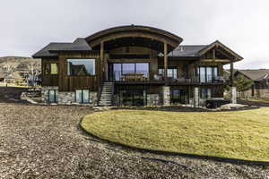 Rear view of property with a balcony and a yard