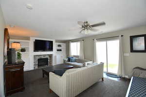 Carpeted living room with ceiling fan