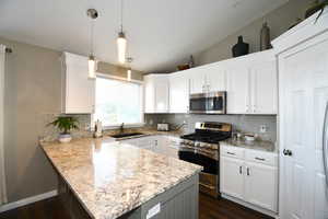 Kitchen featuring white cabinetry, sink, and appliances with stainless steel finishes