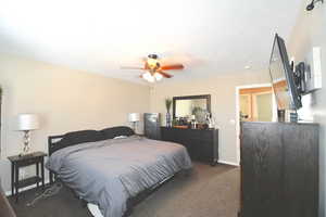 Carpeted bedroom with ceiling fan