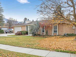 Ranch-style house with a garage and a front lawn