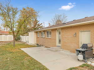 Back of house with a yard and a patio