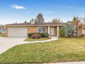 Single story home with a front yard and a garage