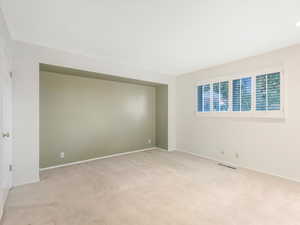 Empty room featuring light colored carpet