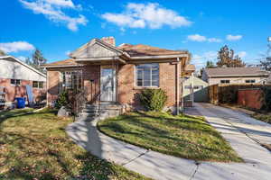 Bungalow featuring a garage, an outbuilding, and a front yard