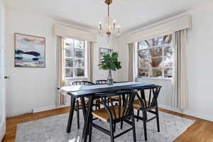 Dining area with light wood  flooring and a notable chandelier