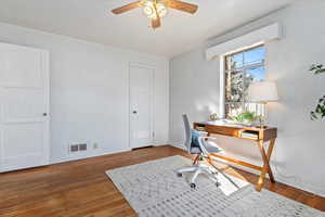 Home office featuring dark hardwood / wood-floors and ceiling fan